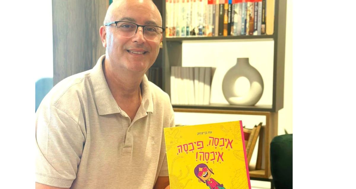 עוז בן יצחק מחזיק את ספר הילדים שלו "איכסה פיכסה איכסה", צילום: עם עובד