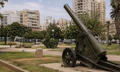 איור בינה מלאכותית של תותח דוידקה המוצב בגינה ציבורית כאנדרטה בקרבת שכונת מגורים עם בניינים