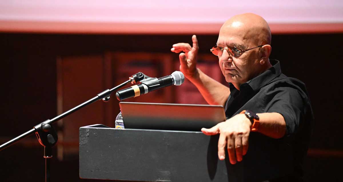 מוטי נחמני, מנכ"ל החברה העירונית לביטחון וסדר ציבורי, עומד מאחורי דוכן נואמים ומיקרופון.
