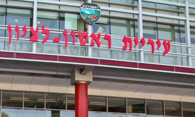 בניין עיריית ראשון לציון, עם כיתוב גדול: עיריית ראשון-לציון וסמל העיר מעל הכיתוב.