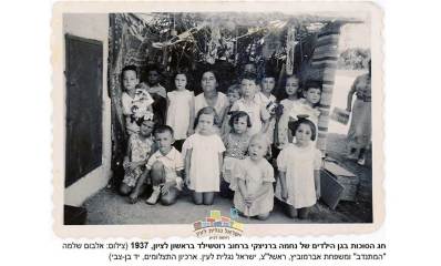 חג הסוכות בגן הילדים של נחמה ברניצקי ברחוב רוטשילד בראשון לציון 1937. גננת ו-14 ילדות וילדים.