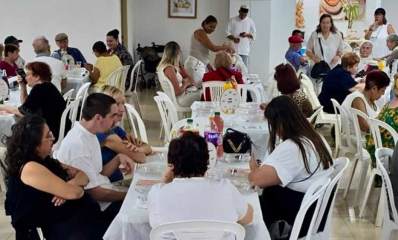 אזרחים ותיקים בפעילות של עיריית ראשון לציון. מסבים לשולחנות עם מפות לבנות וכסאות כתר מפלסטיק