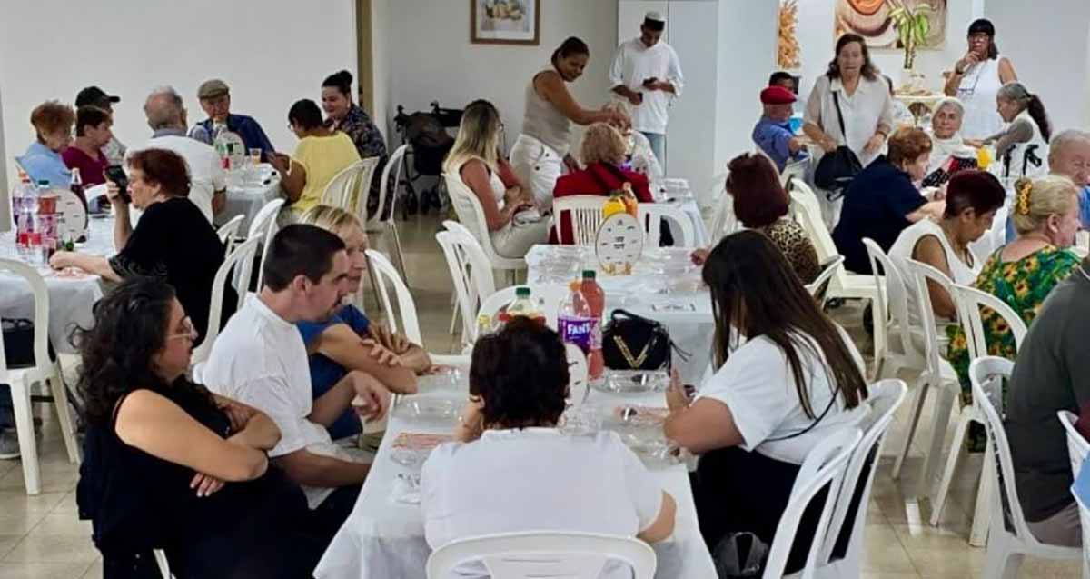 אזרחים ותיקים בפעילות של עיריית ראשון לציון. מסבים לשולחנות עם מפות לבנות וכסאות כתר מפלסטיק