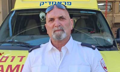 מתנדב 29 שנה. איתי מוסקל במדי מד"א על רקע של אמבולנס.